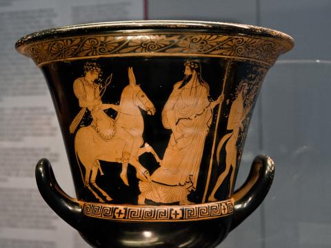 Hephaestus returns to Olympus riding a donkey and carrying hammer and tongs. He is led by Dionysus, who bears a thyrsos (pine-cone tipped staff) and drinking cup.