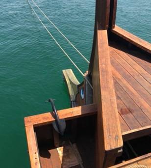 The pointed wooden prow of a boat above the sea