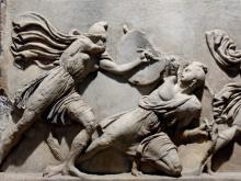 Amazonomachy scene: An Amazon woman warrior (left) doing battle with a Greek on a frieze (decorative band that runs the length of a building's wall) panel from the Halicarnassus Mausoleum and now at the British Museum.