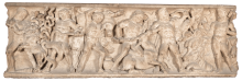A beige sarcophagus covered in relief carvings of men and animals.
