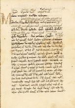 A yellowed manuscript page with Ancient Greek script written on it, with large margins and a letter M drop cap at the beginning.