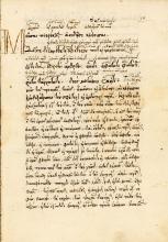A yellow page with a large capital letter M on the top left, followed by handwritten lines of ancient Greek