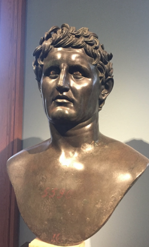 A bronze bust of a man with short, wavy hair and a slightly pained expression on his face.