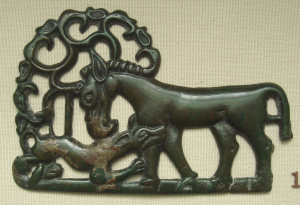 Bronze statuette showing a smaller animal biting the leg of a horse, which stands above it.